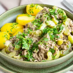 Schmorgurken mit Hackfleisch und Salzkartoffeln, garniert mit frischer Petersilie. Ein herzhaftes Gericht, das auf den Tisch kommt.