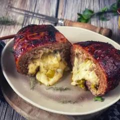 Herzhaft gefüllter Hackbraten, eine wahre "Bacon Bomb", mit geschmolzenem Käse und Paprika.