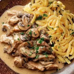 Ein köstliches Schweinegeschnetzeltes Rezept mit cremiger Pilzsoße und Spätzle, garniert mit frischer Petersilie.