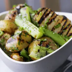 Schmackhaftes Gericht mit gegrillten Kartoffeln und Sellerie, garniert mit frischer Petersilie und grobem Salz. Perfekt für den Sommer.