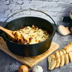 Herzhafter Gyros-Eintopf im Dutch Oven, mit geschmolzenem Käse und Baguette.
