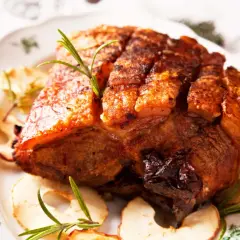 Knuspriger Schweinebauch mit Rosmarin und Apfelscheiben. Die perfekte Kerntemperatur für saftigen Genuss.