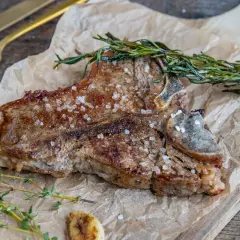 Perfekt gegrilltes Kalbskotelett mit Kräutern und grobem Salz. Die Kerntemperatur ist entscheidend für den perfekten Garpunkt.
