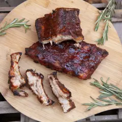 Saftige Spareribs vom Grill, glasiert und mit Rosmarin garniert, warten auf hungrige Genießer.
