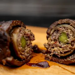 Zwei saftige Rouladen, im Dutch Oven geschmort, zeigen ihre köstliche Füllung aus Gurke und Zwiebeln.