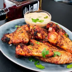 Saftige chicken wings grillen mit Dip und einer Flasche Whiskey. Perfekt für den Sommer!