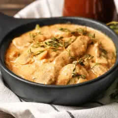 Cremiges Boeuf Stroganoff Rezept mit zarten Fleischstreifen und Pilzen, garniert mit frischem Thymian.