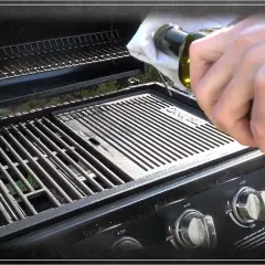 Einbrennen des Gasgrills: Öl wird mit einem Tuch auf die Grillplatte aufgetragen, um sie für das erste Grillen vorzubereiten.