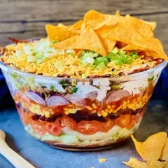 Schichtsalat mit Hackfleisch, Bohnen, Mais, Tomaten, Zwiebeln, Käse und Tortilla-Chips. Perfekt für Taco-Salat Rezepte!