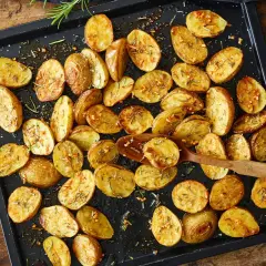 Goldbraune, knusprige Kartoffelspalten mit Rosmarin und Knoblauch, bereit für ein köstliches Ofenkartoffeln Rezept.