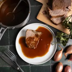Zarter Rinderbraten im Backofen, serviert mit reichlich Sauce. Ein Festmahl, das auf dem Tisch wartet.