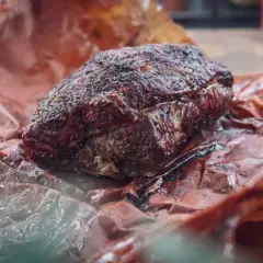 Saftiges, langsam gegartes Pulled Pork im Texas-Style, umhüllt von rauchiger Kruste und Gewürzen, ruht auf Butcher Paper.