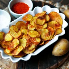 Selbstgemachte Kartoffelchips, goldbraun und knusprig, mit Salz und Paprikapulver. So einfach ist kartoffelchips selber machen!