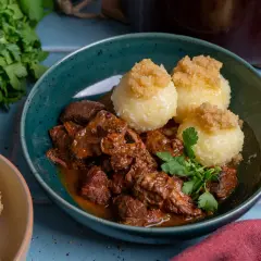 Herzhaftes Gulasch mit Klößen, ein klassisches Gulasch Rezept, garniert mit Petersilie.
