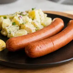 Zwei Wiener Würstchen mit Kartoffelsalat und Senf. Perfekt, wenn man wissen möchte, wie lange Wiener kochen.