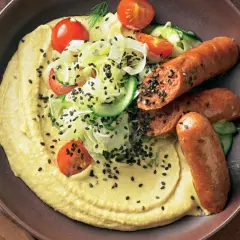 Hummus mit gegrillten Merguez-Würstchen, Tomaten, Gurken und schwarzem Sesam. Ein einfaches Merguez Rezept für Genießer.