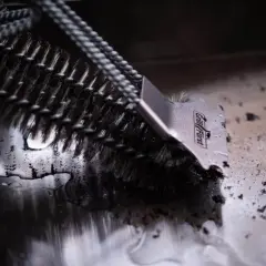 Grillbürste im Einsatz: So einfach gelingt die **Plancha reinigen** nach dem Grillen.