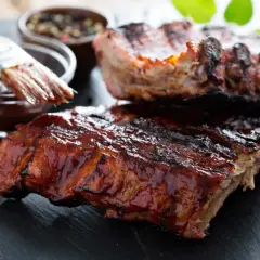 Saftige Spareribs mit glänzender BBQ-Sauce, bereit zum Servieren. Die Kerntemperatur ist perfekt für zartes Fleisch.