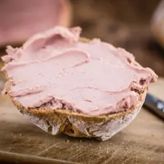 Ein Brötchen mit leckerer Leberwurst bestrichen. Ob Leberwurst gesund ist, hängt von der Zubereitung ab.