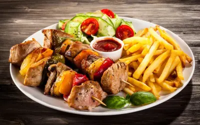 Schaschlikspieße mit Paprika und Zwiebeln, dazu Pommes Frites und ein kleiner Salat – eine köstliche schaschlik beilage.