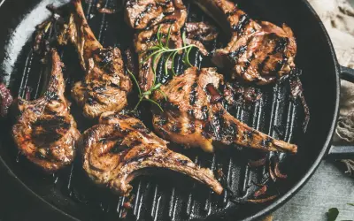 Saftiges Lammfilet grillen in einer Pfanne mit Rosmarin und Zwiebeln. Perfekt gegrillte Lammkoteletts mit köstlichen Röstaromen.