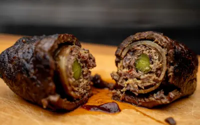Zwei saftige Rouladen, im Dutch Oven geschmort, zeigen ihre köstliche Füllung aus Gurke und Zwiebeln.
