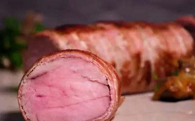 Perfekt gegartes sous-vide schweinefilet, umhüllt von knusprigem Speck. Eine köstliche Beilage, die auf jeder sous-vide schweinefilet tabelle glänzt.