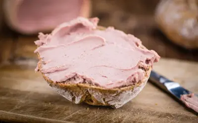Ein Brötchen mit leckerer Leberwurst bestrichen. Ob Leberwurst gesund ist, hängt von der Zubereitung ab.