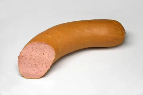 Eine aufgeschnittene Fleischwurst mit feiner, rosa Einlage. Der Unterschied zur Lyoner ist die gröbere Struktur.