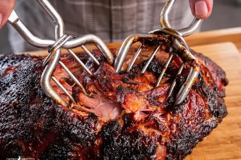 Saftiges Pulled Pork, perfekt für deine Smoker Rezepte. Mit zwei Fleischgabeln wird das zarte Fleisch auseinandergezogen.