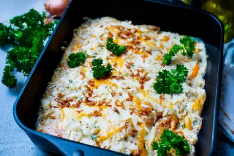 Zwiebel Sahne Schnitzel überbacken mit Käse und garniert mit Petersilie. Knusprige Zwiebeln und cremige Sauce machen dieses Gericht unwiderstehlich.
