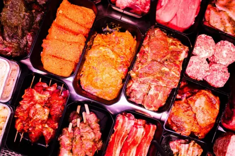 Fleischtheke mit mariniertem Fleisch, Spießen und Hackbällchen. Hier findet man auch Zutaten für ein deftiges Frühstück, wie zum Beispiel Mett.