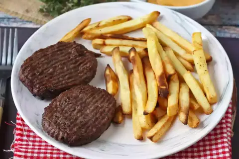 Zwei Hacksteaks mit Pommes Frites auf einem Teller. Ein einfaches Hacksteak rezept für einen schnellen Genuss.
