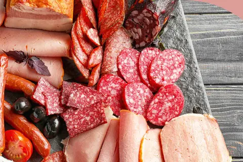 Eine Auswahl an Wurstwaren: Salamischeiben, Kochschinken, Bratwürste und Speck. Die Vielfalt zeigt die **Definition Wurst** in ihrer ganzen Pracht.