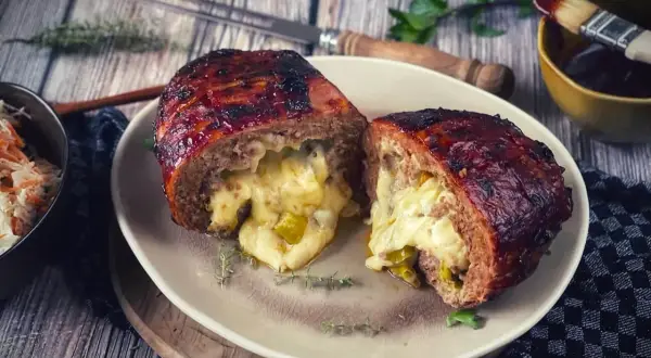 Herzhaft gefüllter Hackbraten, eine wahre "Bacon Bomb", mit geschmolzenem Käse und Paprika.