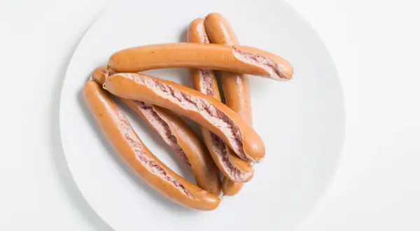 Ein Haufen gekochter Würstchen auf einem Teller. Wie lange wurst kochen?