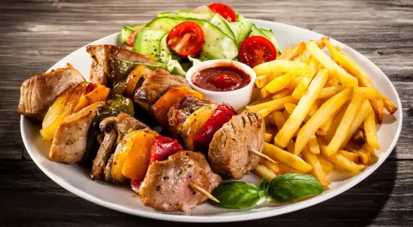 Schaschlikspieße mit Paprika und Zwiebeln, dazu Pommes Frites und ein kleiner Salat – eine köstliche schaschlik beilage.