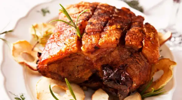 Knuspriger Schweinebauch mit Rosmarin und Apfelscheiben. Die perfekte Kerntemperatur für saftigen Genuss.
