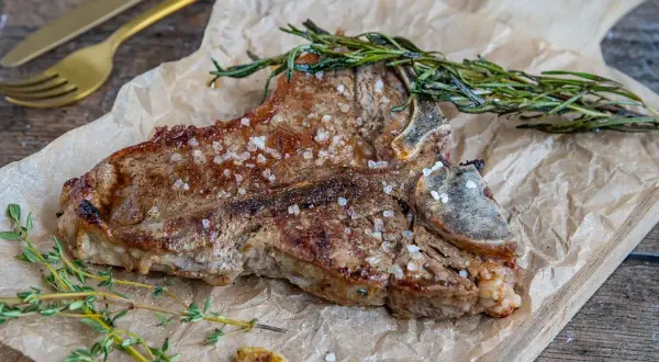 Perfekt gegrilltes Kalbskotelett mit Kräutern und grobem Salz. Die Kerntemperatur ist entscheidend für den perfekten Garpunkt.
