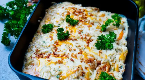 Zwiebel Sahne Schnitzel überbacken mit Käse und garniert mit Petersilie. Knusprige Zwiebeln und cremige Sauce machen dieses Gericht unwiderstehlich.