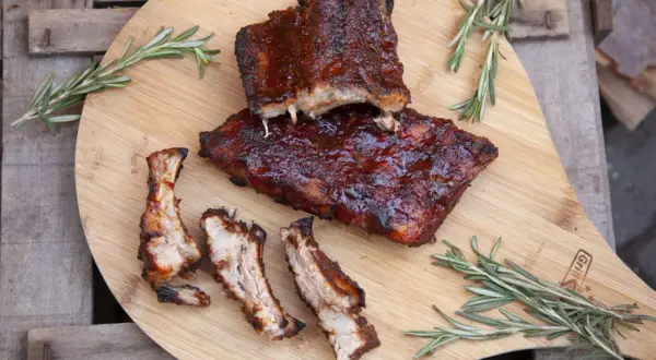 Saftige Spareribs vom Grill, glasiert und mit Rosmarin garniert, warten auf hungrige Genießer.