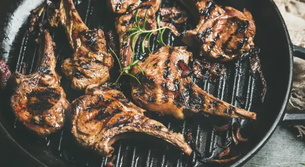 Saftiges Lammfilet grillen in einer Pfanne mit Rosmarin und Zwiebeln. Perfekt gegrillte Lammkoteletts mit köstlichen Röstaromen.