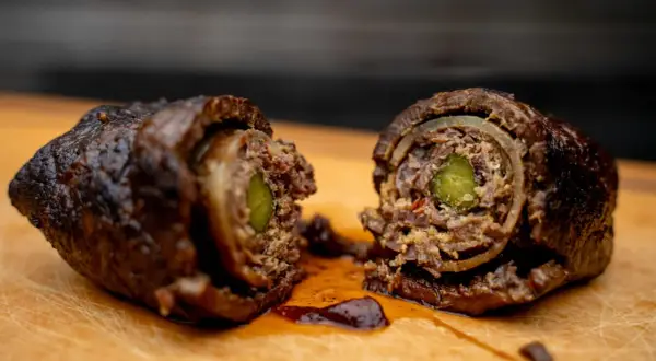 Zwei saftige Rouladen, im Dutch Oven geschmort, zeigen ihre köstliche Füllung aus Gurke und Zwiebeln.