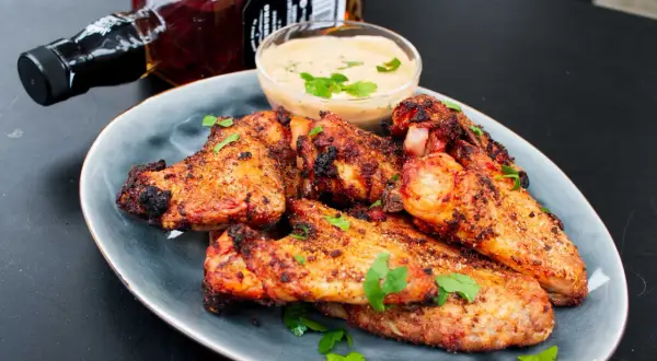 Saftige chicken wings grillen mit Dip und einer Flasche Whiskey. Perfekt für den Sommer!