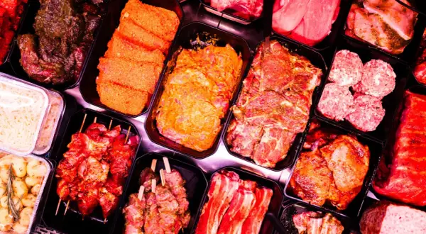 Fleischtheke mit mariniertem Fleisch, Spießen und Hackbällchen. Hier findet man auch Zutaten für ein deftiges Frühstück, wie zum Beispiel Mett.