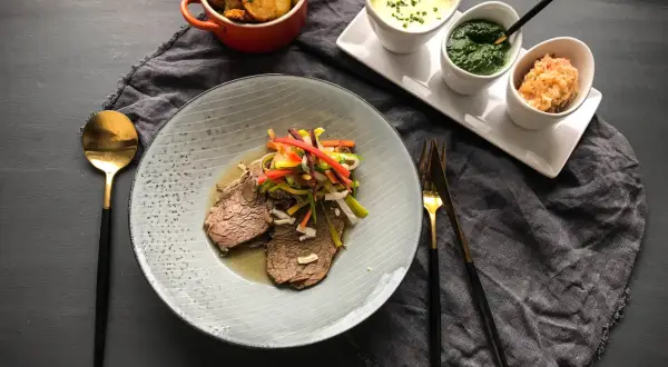 Ein köstliches Tafelspitz-Rezept mit zartem Rindfleisch, bunten Gemüsestreifen, Bratkartoffeln und drei Saucen.