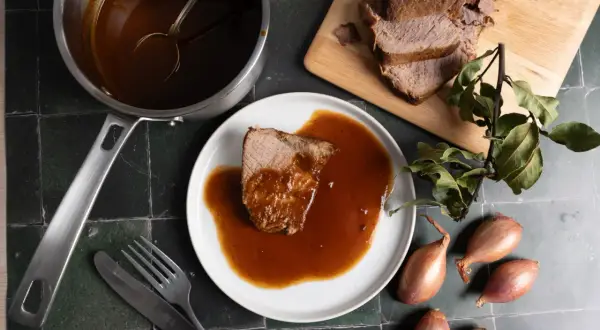 Zarter Rinderbraten im Backofen, serviert mit reichlich Sauce. Ein Festmahl, das auf dem Tisch wartet.