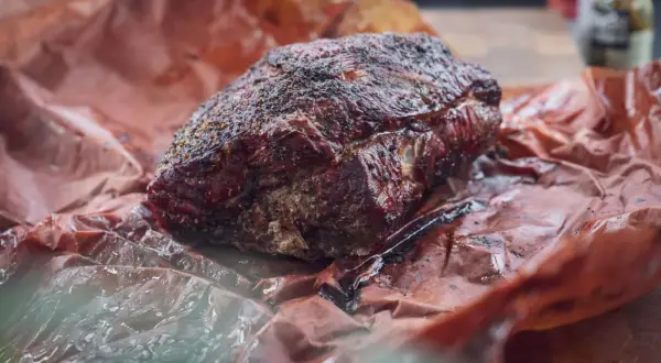 Saftiges, langsam gegartes Pulled Pork im Texas-Style, umhüllt von rauchiger Kruste und Gewürzen, ruht auf Butcher Paper.