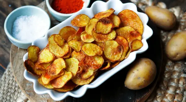 Selbstgemachte Kartoffelchips, goldbraun und knusprig, mit Salz und Paprikapulver. So einfach ist kartoffelchips selber machen!