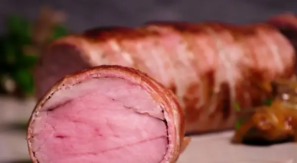 Perfekt gegartes sous-vide schweinefilet, umhüllt von knusprigem Speck. Eine köstliche Beilage, die auf jeder sous-vide schweinefilet tabelle glänzt.